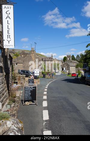 Le village de Muker, Yorkshire du Nord. La vue montre la route principale à travers le village en regardant vers l'église. Banque D'Images