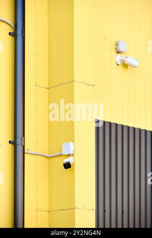 Caméra CCTV. Caméra de sécurité sur les panneaux composites en aluminium pour la réparation restaurer la façade du mur de grange d'entrepôt de bâtiment commercial, deux CCTV sur les bâtiments Banque D'Images