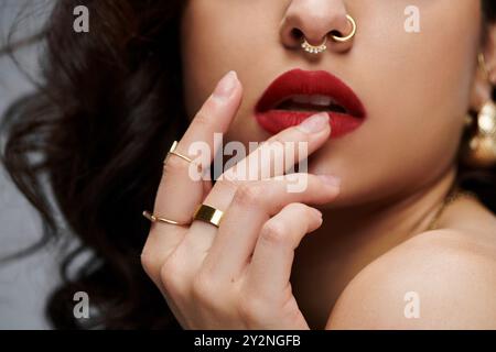 Une belle jeune femme pose avec confiance, ornée de bijoux chatoyants. Banque D'Images