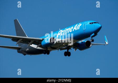 Boeing 737 avion Amazon Prime Air avion cargo volant dans un ciel bleu clair avec train d'atterrissage étendu, Leipzig Allemagne Europe Amazon avion Banque D'Images