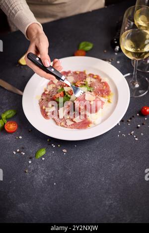 cuisson carpaccio de thon - morceaux de tomates cerises sur une assiette avec des tranches de filet de thon cru Banque D'Images