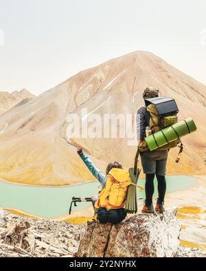 Heureux jeune couple millénaire profiter de la vue sur les montagnes du caucase debout sur le célèbre lac Kelitsadi d'eau turquoise Banque D'Images