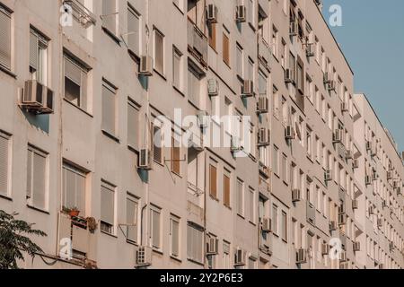 Fenêtres avec volets et unités de climatisation sur le mur d'un grand immeuble dans le centre-ville de Podgorica au Monténégro dans les Balkans. Banque D'Images