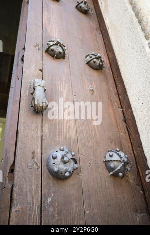 Doorknocker avec forme de main sur la vieille porte en bois brun avec des détails en fer forgé dans la ville d'Avila, Espagne Banque D'Images