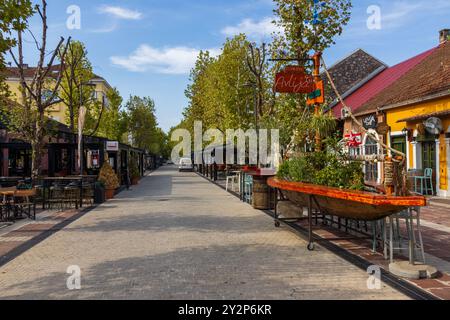 Tables et chaises à l'extérieur des restaurants et cafés colorés sur la rue Njegoševa dans le centre-ville de Podgorica au Monténégro par un matin d'été ensoleillé et calme. Banque D'Images