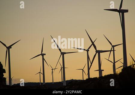 silhouettes de moulins à vent sur une montagne au coucher du soleil, heure dorée. Concept d'énergie renouvelable Banque D'Images