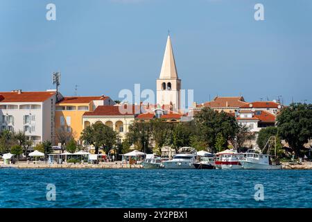 Porec, Istrie, Croatie - 27 août 2024 : la vieille ville pittoresque de Porec, Croatie, avec sa tour d'église frappante et ses bâtiments méditerranéens colorés sur les rives de la mer Adriatique. La ville côtière est une destination populaire pour les touristes qui veulent profiter de l'architecture historique et le flair méditerranéen *** Die malerische Altstadt von Porec, Kroatien, mit ihrem markanten Kirchturm und den bunten mediterranen Gebäuden am Ufer der Adria. Die Küstenstadt ist ein Beliebtes Reiseziel für Touristen, die die historische Architektur und das mediterrane flair genießen möchten Banque D'Images