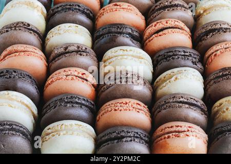 Vue de dessus de table d'une variété de macarons français aromatisés. Chocolat blanc, lait et noir aux arômes d'orange. Banque D'Images