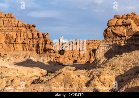 Paysage saisissant mettant en valeur les formations rocheuses uniques du parc d'État de Goblin Valley dans l'Utah, mis en valeur par la lueur chaude de la lumière du soleil. Banque D'Images