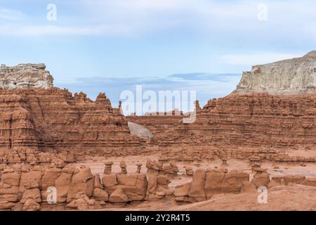 Paysage saisissant mettant en valeur les formations rocheuses uniques du parc d'État de Goblin Valley dans l'Utah, mis en valeur par la lueur chaude de la lumière du soleil. Banque D'Images