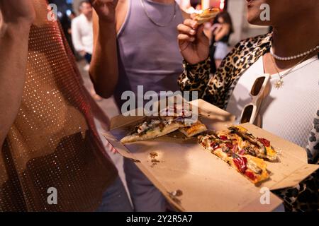 Un groupe diversifié d’amis LGBTQIA+ partagent un moment joyeux, savourant de délicieuses tranches de pizza lors d’une soirée, soulignant l’inclusion et l’amitié. Th Banque D'Images