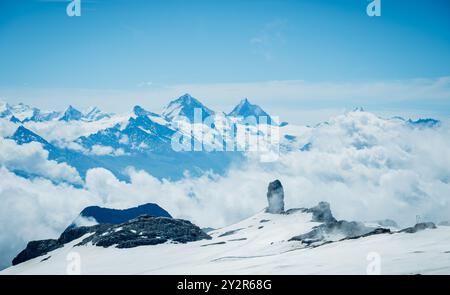 Vue panoramique imprenable sur les sommets enneigés des Diablerettes, les Alpes suisses, s'élevant majestueusement au-dessus de la ligne nuageuse du Glacier 3000 Banque D'Images
