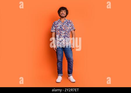Photo pleine grandeur de beau modèle de magasinage jeune homme porter une tenue colorée à la mode isolé sur fond de couleur orange Banque D'Images