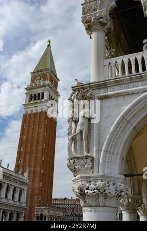 Une vue imprenable sur Venise avec le célèbre Campanile Saint-Marc qui domine derrière des sculptures complexes par une journée lumineuse, mettant en valeur l'architecture Banque D'Images