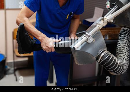 Un technicien qualifié en gommage bleu ajuste méticuleusement une prothèse de jambe dans un environnement de soins de santé, mettant en valeur la précision et la technologie de pointe Banque D'Images