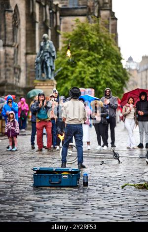 Le busker d'Édimbourg sur les pavés du Royal Mile divertissant la foule Banque D'Images