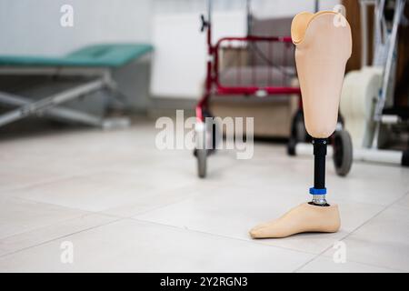 Gros plan d’une prothèse de jambe placée dans un centre de rééducation, avec du matériel médical en arrière-plan, symbolisant l’espoir et le rétablissement. Banque D'Images