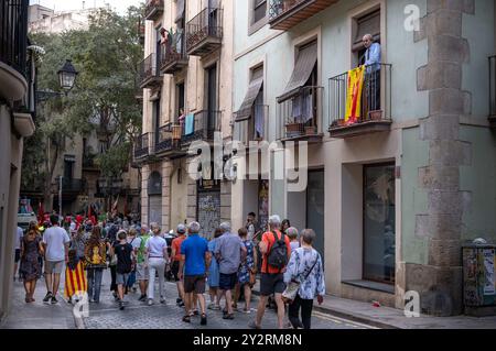 Barcelone, Espagne. 11 septembre 2024. Un homme est vu sur son balcon décoré du drapeau pour l'indépendance de la Catalogne alors qu'il regarde un flot de personnes célébrant la fête nationale de Catalogne dans la rue. Barcelone célèbre la fête nationale de Catalogne en souvenir de la reddition de Barcelone à l'armée des Bourbons pendant la guerre de succession. Crédit : SOPA images Limited/Alamy Live News Banque D'Images