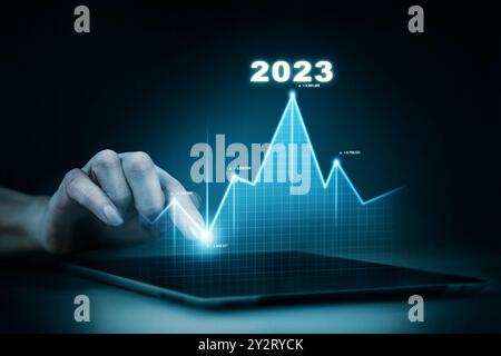 Nouveaux objectifs, plans et visions pour l'année prochaine 2023. L'homme d'affaires dessine l'augmentation graphique de flèche de croissance future de l'entreprise année 2022 à 2023. Planification, opportunité Banque D'Images