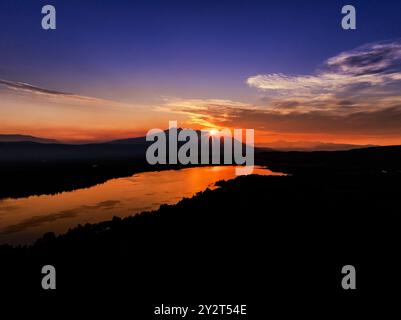 Le soleil se couche sur Smithers en Colombie-Britannique au Canada reflétant le ciel orange sur le lac Banque D'Images