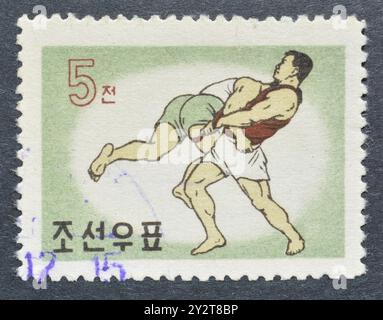 Timbre-poste annulé imprimé par la Corée du Nord, qui montre Wrestling, vers 1960. Banque D'Images