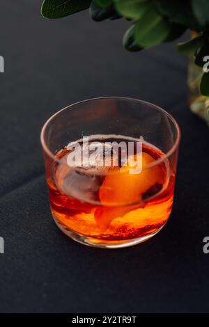Cocktail de whisky dans le verre de roches basses avec de la glace et écorce d'orange sur fond noir Banque D'Images