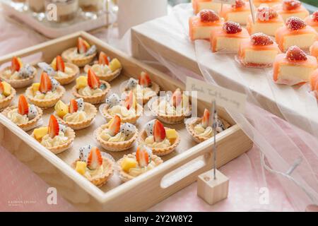 Assortiment de tartes aux fruits et de desserts présentés sur un plateau en bois à une boulangerie ou à une table de desserts. Banque D'Images