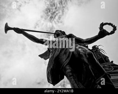 Vue en noir et blanc à angle bas d'une grande sculpture d'ange jouant de la trompette, faisant partie du monument du pont Boyaca en Colombie Banque D'Images