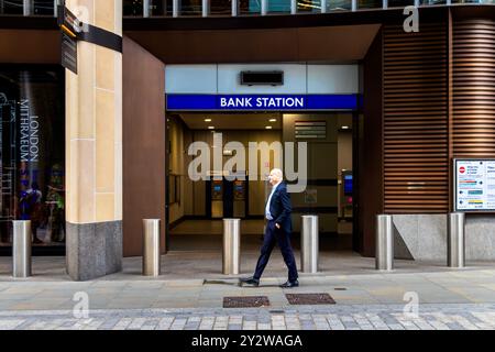 Un homme en costume passant devant l'entrée Walbrook de la station Bank située sous le Bloomberg Building dans la ville de Londres, Royaume-Uni Banque D'Images