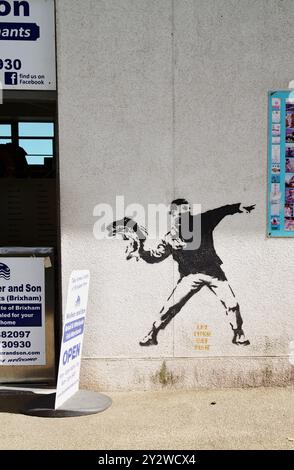 Street Art of A Man IN Bandana face Mask Throwing A Fish, Let Them Eat Fish, Ouside A Seafood Vendors Shop, Brixham Devon UK Banque D'Images