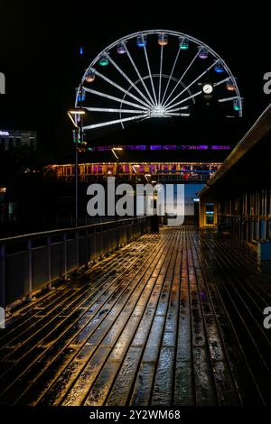 Jetées britanniques en bord de mer, jetée de Bournemouth la nuit, reflets pluvieux, grande roue Banque D'Images