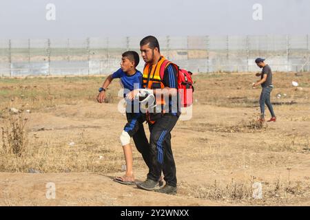 Gaza City, Palestine. 24 mai 2019. Les Palestiniens manifestent lors de ce grand rassemblement de marche du retour de vendredi dans la région de Malika à l’est de la ville de Gaza, près de la frontière avec Israël. Les manifestants palestiniens se sont rassemblés sur différents sites à Gaza près de la frontière avec Israël pour les manifestations hebdomadaires de ce vendredi et des affrontements ont éclaté entre eux et les soldats israéliens. 16 Palestiniens, dont un paramédical, ont été blessés par des balles en caoutchouc et par inhalation de gaz utilisés par les forces israéliennes pour disperser les manifestants. Depuis le 30 mars 2018, les Palestiniens de Gaza organisent au moins une fois par semaine des manifestations contre Banque D'Images