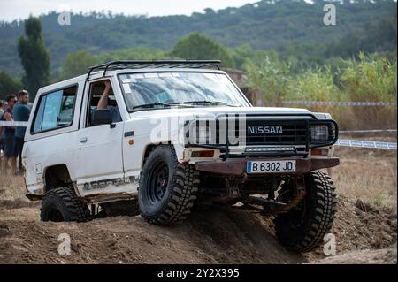 Vue avant d'un véhicule tout-terrain japonais de troisième génération Nissan Patrol série 160 blanc classique surmontant un obstacle sur la piste 4x4 Banque D'Images