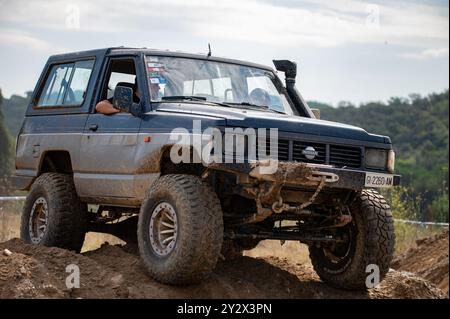 Véhicule tout-terrain Nissan Patrol série 260 de troisième génération modifié pour la conduite hors route extrême en surmontant un obstacle boueux dans la campagne Banque D'Images