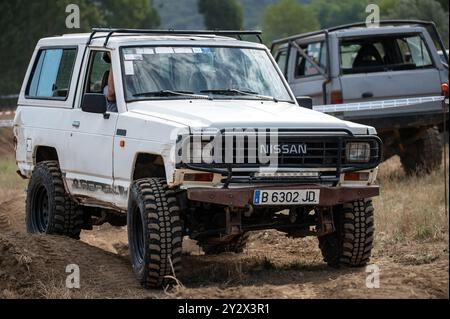 Vue avant d'un véhicule tout-terrain japonais de troisième génération Nissan Patrol série 160 blanc classique surmontant un obstacle sur la piste 4x4 Banque D'Images