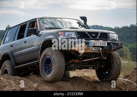 Impressionnant Nissan Patrol GR Y61 véhicule tout-terrain de cinquième génération hautement modifié pour le tout-terrain extrême en surmontant un obstacle dans la campagne Banque D'Images