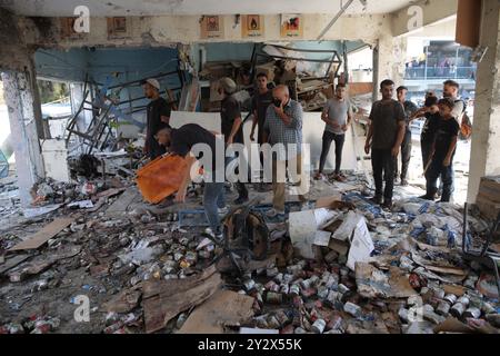 Gaza. 11 septembre 2024. Des gens sont vus dans une école gérée par l’ONU abritant des personnes déplacées après qu’elle ait été attaquée par l’armée israélienne dans le camp de réfugiés d’al-Nuseirat, dans le centre de la bande de Gaza, le 11 septembre 2024. Au moins 14 Palestiniens ont été tués et 10 autres blessés dans une frappe aérienne israélienne sur une école gérée par l'ONU abritant des personnes déplacées dans le centre de la bande de Gaza, selon des sources palestiniennes mercredi. Crédit : Marwan Dawood/Xinhua/Alamy Live News Banque D'Images