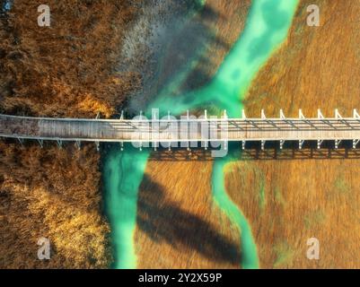 Vue aérienne du pont en bois, de la rivière Azur et de l'herbe orange Banque D'Images