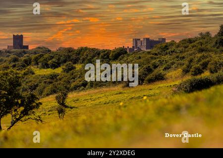 Vue panoramique sur le château de Douvres au coucher du soleil avec un paysage verdoyant luxuriant et un ciel vibrant. Banque D'Images