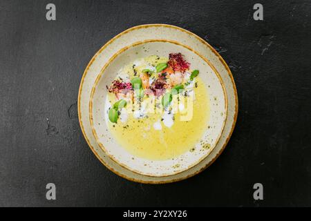 Soupe gastronomique crémeuse avec crevettes, microgreens et présentation artistique - plat gastronomique élégant Banque D'Images