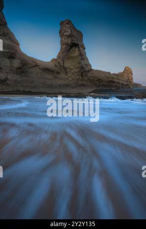 Un magnifique paysage marin avec une formation rocheuse spectaculaire avec des vagues se précipitant vers le rivage au coucher du soleil. Banque D'Images