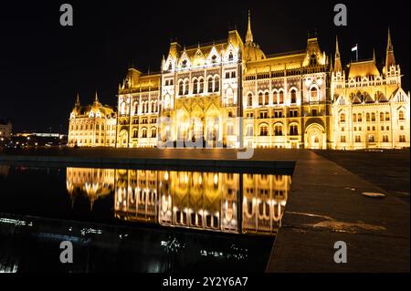 Budapest, Hongrie. 24 août 2022. Incroyable cliché nocturne du parlement. L'éclairage rehausse la beauté et l'élégance du bâtiment. Réflexion de Banque D'Images