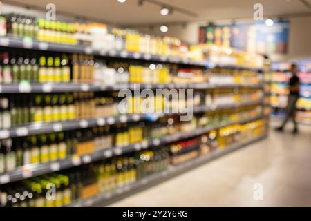 Étagères abstraites floues dans un supermarché. Décor flou à l'intérieur de l'épicerie, large gamme de marchandises, allée de supermarché dynamique, environnement de magasinage Banque D'Images