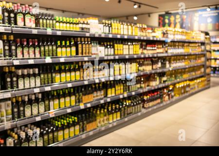 Étagères abstraites floues dans un supermarché. Décor flou à l'intérieur de l'épicerie, large gamme de marchandises, allée de supermarché dynamique, environnement de magasinage Banque D'Images