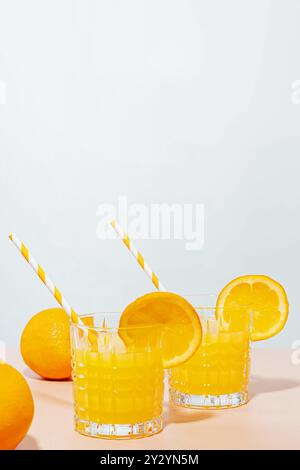 Deux verres de jus d'orange fraîchement pressé avec des pailles et des tranches, petit déjeuner sain Banque D'Images