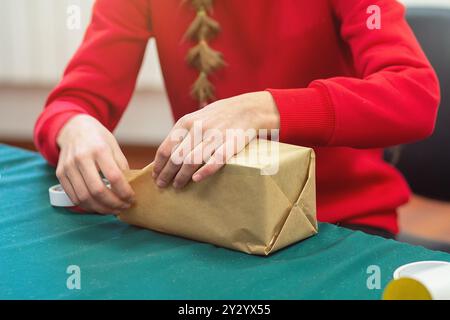 Fille emballe un colis dans du papier d'emballage pour l'envoi. Service postal Banque D'Images