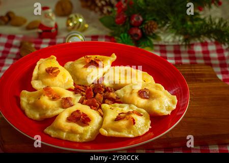 Piérogies de Noël traditionnelles avec cheddar et garniture de pommes de terre et bacon sur la table de fête Banque D'Images