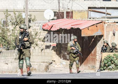 Tubas, Palestine. 11 septembre 2024. Une force d'infanterie israélienne est vue dans le centre de la ville de Tubas lors du raid sur la ville de Tubas. Un raid militaire israélien de grande envergure contre la ville de Tubas, dans le nord de la Cisjordanie occupée, a permis de tuer cinq Palestiniens dans une frappe aérienne et les forces ont encerclé un hôpital palestinien et empêché le personnel médical de transporter des patients à destination et en provenance de celui-ci. Crédit : SOPA images Limited/Alamy Live News Banque D'Images
