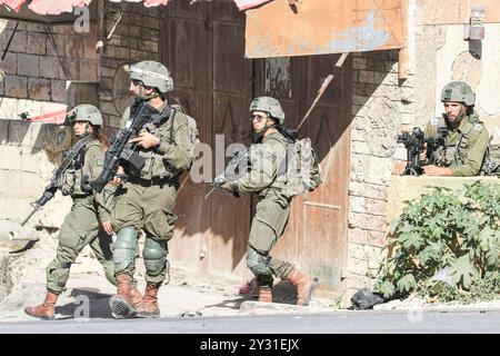 Tubas, Palestine. 11 septembre 2024. Une force d'infanterie israélienne est vue dans le centre de la ville de Tubas lors du raid sur la ville de Tubas. Un raid militaire israélien de grande envergure contre la ville de Tubas, dans le nord de la Cisjordanie occupée, a permis de tuer cinq Palestiniens dans une frappe aérienne et les forces ont encerclé un hôpital palestinien et empêché le personnel médical de transporter des patients à destination et en provenance de celui-ci. Crédit : SOPA images Limited/Alamy Live News Banque D'Images