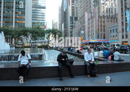 New York, États-Unis. 10 septembre 2024. Les gens sont assis près d'une fontaine d'eau comme Radio City Music Hall est vu en arrière-plan à Manhattan, New York City. Crédit : SOPA images Limited/Alamy Live News Banque D'Images